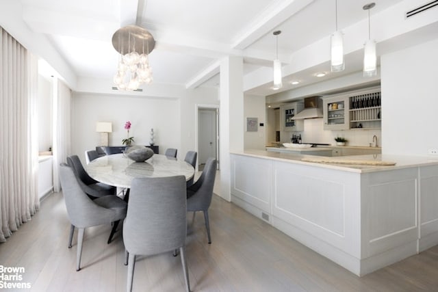 595 W End Ave Unit 9Fl, New York City, NY 10024 - dining space featuring light wood-type flooring, a chandelier, and beamed ceiling