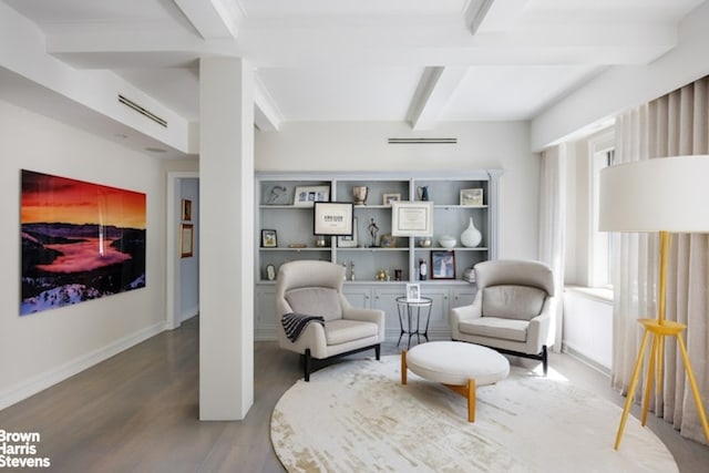 sitting room with beam ceiling, wood finished floors, and baseboards