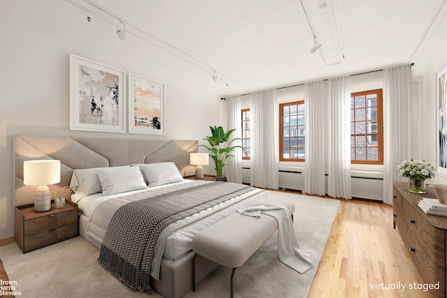 bedroom featuring track lighting and light wood-type flooring
