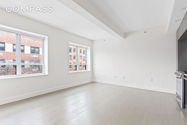 unfurnished living room featuring wood finished floors and baseboards