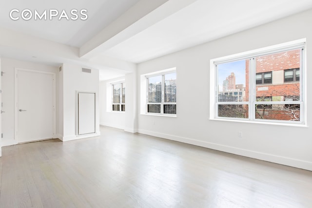 unfurnished living room featuring wood finished floors, baseboards, and beamed ceiling