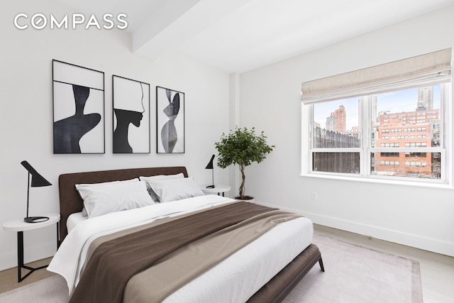 bedroom featuring baseboards, a view of city, wood finished floors, and beam ceiling