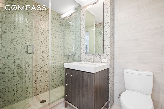 full bath featuring tile walls, a shower stall, toilet, and vanity