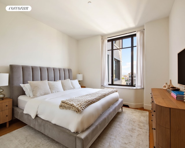 bedroom featuring light wood-style flooring and baseboards