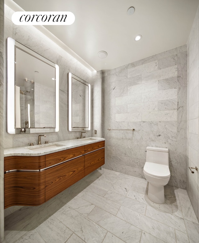 full bath featuring double vanity, toilet, tile walls, marble finish floors, and recessed lighting