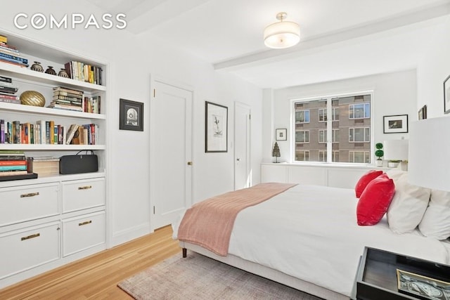 350 E 57th St Unit 14B, New York City, NY 10022 - bedroom featuring light wood-style flooring and beamed ceiling