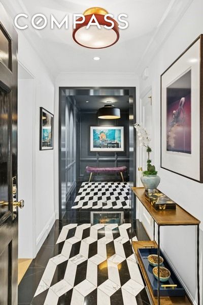 350 E 57th St Unit 14B, New York City, NY 10022 - hall with tile patterned flooring, crown molding, and a decorative wall