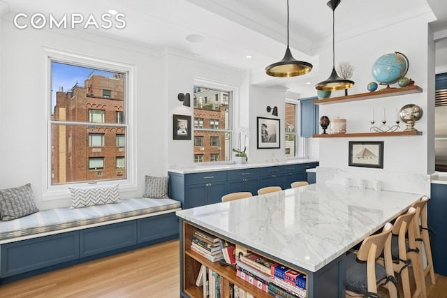 350 E 57th St Unit 14B, New York City, NY 10022 - kitchen featuring open shelves, blue cabinets, light wood finished floors, a peninsula, and a kitchen bar