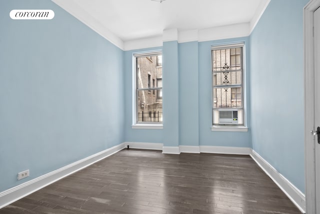 empty room featuring dark wood-type flooring and baseboards