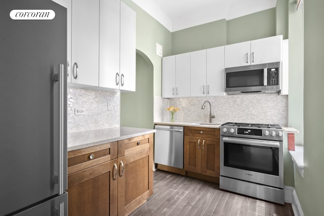 318 W 100th St Unit 1D, New York City, NY 10025 - kitchen with stainless steel appliances, light countertops, light wood-style floors, a sink, and white cabinets