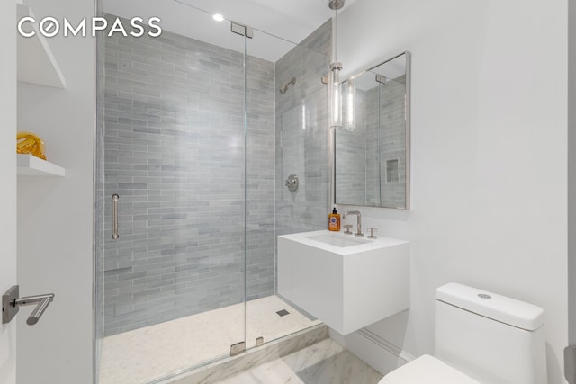 bathroom featuring a sink, toilet, and a shower stall