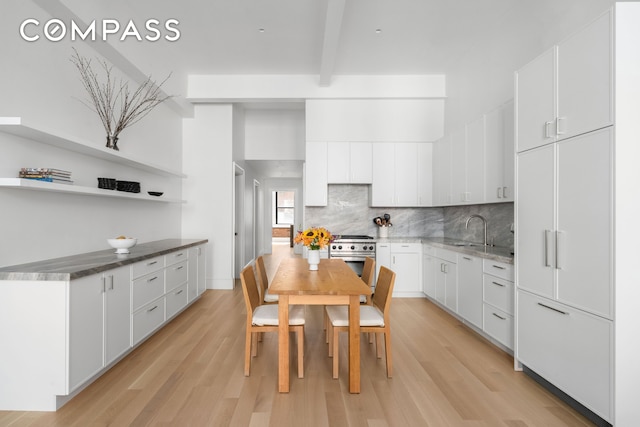 51 Warren St Unit 3W, New York City, NY 10007 - kitchen with high end stove, tasteful backsplash, light wood-style flooring, beam ceiling, and white cabinetry