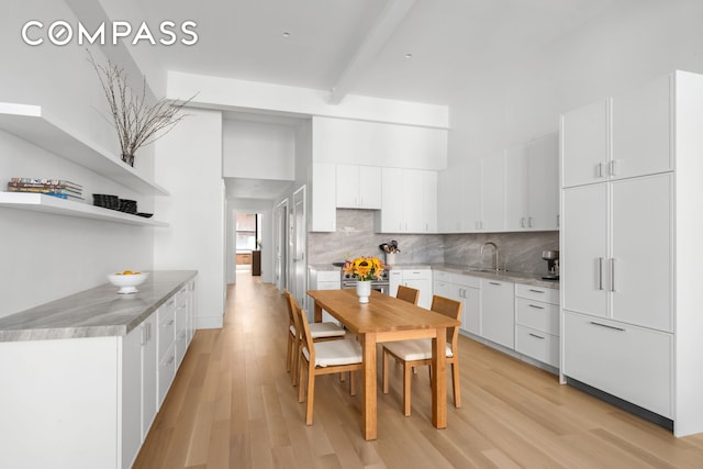51 Warren St Unit 3W, New York City, NY 10007 - kitchen with light wood finished floors, tasteful backsplash, white cabinetry, a sink, and beamed ceiling