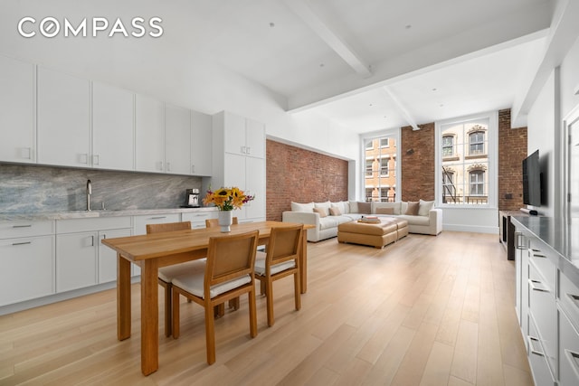 51 Warren St Unit 3W, New York City, NY 10007 - dining room with beamed ceiling, light wood-style floors, and brick wall