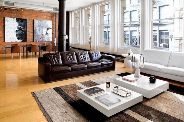 living area featuring wood finished floors, baseboard heating, and a wood stove