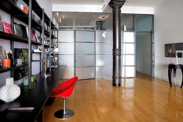 unfurnished office featuring hardwood / wood-style flooring and baseboards