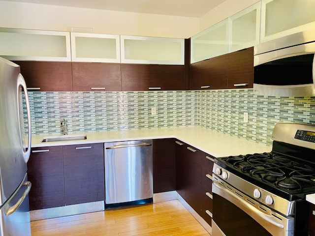 353 E 104th St Unit 6-A, New York City, NY 10029 - kitchen featuring stainless steel appliances, a sink, light countertops, light wood-style floors, and tasteful backsplash