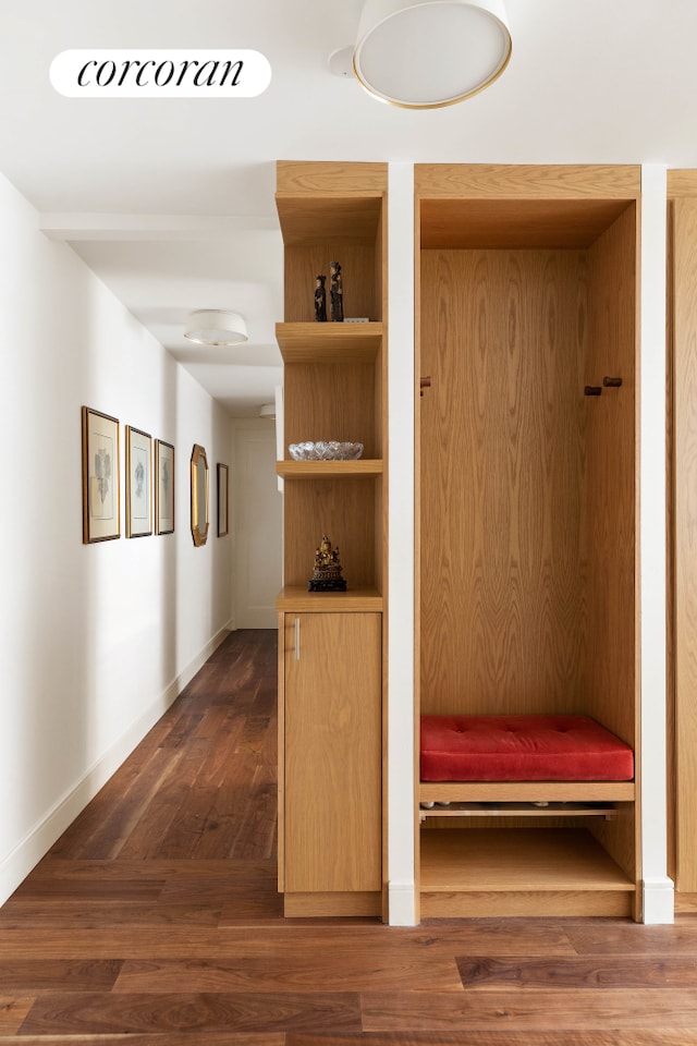 mudroom with dark wood finished floors and baseboards