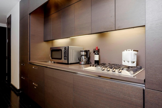20 Pine St Unit 1607, New York City, NY 10005 - kitchen featuring appliances with stainless steel finishes, modern cabinets, light countertops, and dark brown cabinets