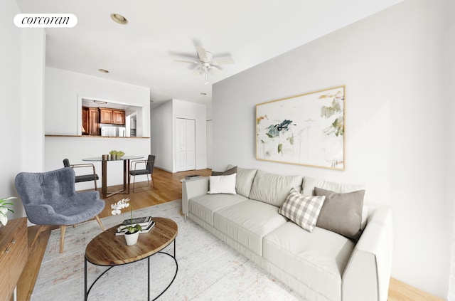 living room featuring light wood finished floors and ceiling fan