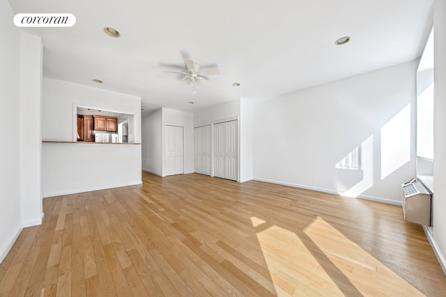 unfurnished living room featuring ceiling fan, light wood-style flooring, baseboards, and recessed lighting
