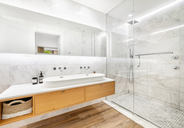 318 E 81st St Unit 1, New York City, NY 10028 - full bathroom with tile walls, a shower stall, wood finished floors, and vanity