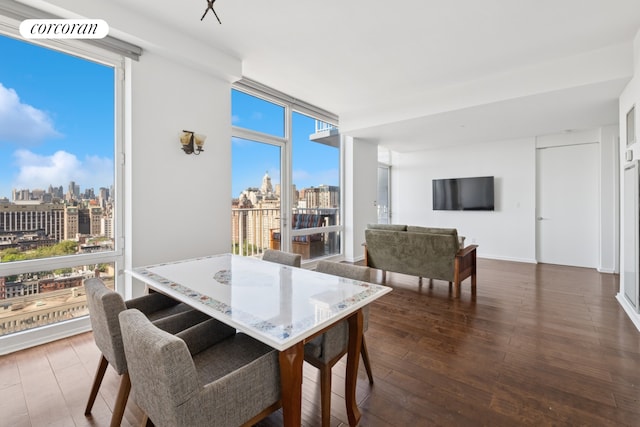 340 E 23rd St Unit Ph2F, New York City, NY 10010 - dining area featuring a skyline view, dark wood finished floors, and healthy amount of natural light