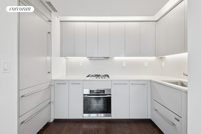 340 E 23rd St Unit Ph2F, New York City, NY 10010 - kitchen featuring stainless steel oven, a sink, gas cooktop, light countertops, and dark wood-type flooring