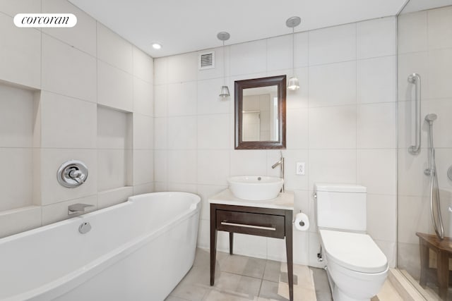 340 E 23rd St Unit Ph2F, New York City, NY 10010 - full bath with tile walls, a soaking tub, vanity, toilet, and tile patterned flooring