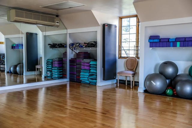 12-06 Robin Ln Unit 1028, New York City, NY 11360 - workout room with a wall mounted AC, wood finished floors, and lofted ceiling