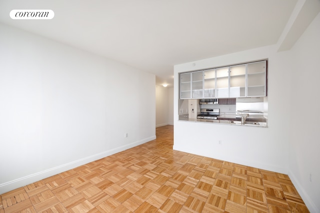 unfurnished living room with baseboards and a sink
