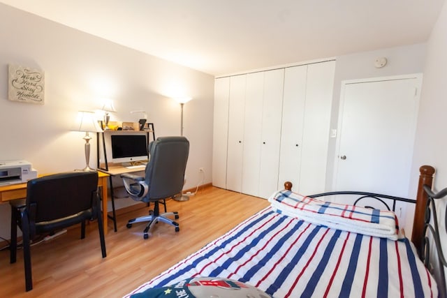 bedroom with wood finished floors, a closet, and a desk