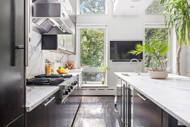 262 W 25th St, New York City, NY 10001 - kitchen with under cabinet range hood, freestanding refrigerator, a baseboard radiator, stainless steel gas cooktop, and backsplash