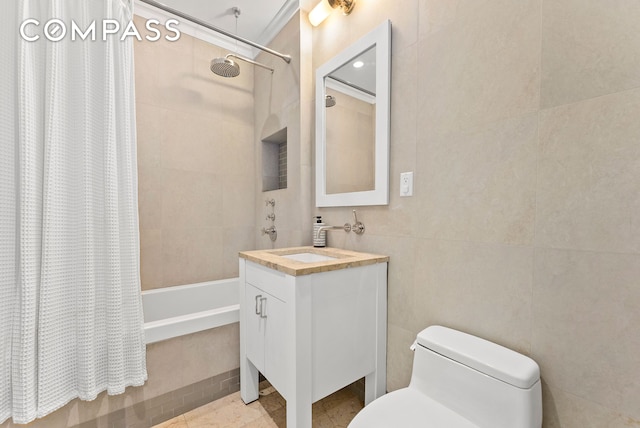 bathroom featuring tile walls, tiled shower / bath, toilet, and vanity