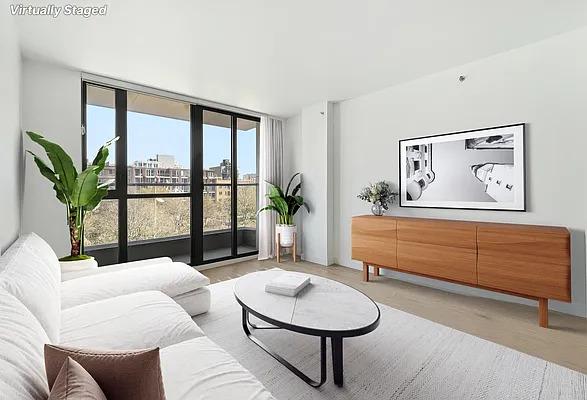 living area with floor to ceiling windows, a view of city, and light wood-style floors