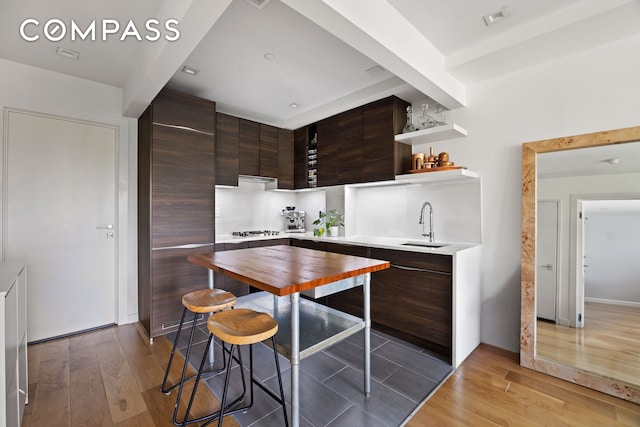 kitchen featuring modern cabinets, dark brown cabinets, light wood-style flooring, and open shelves