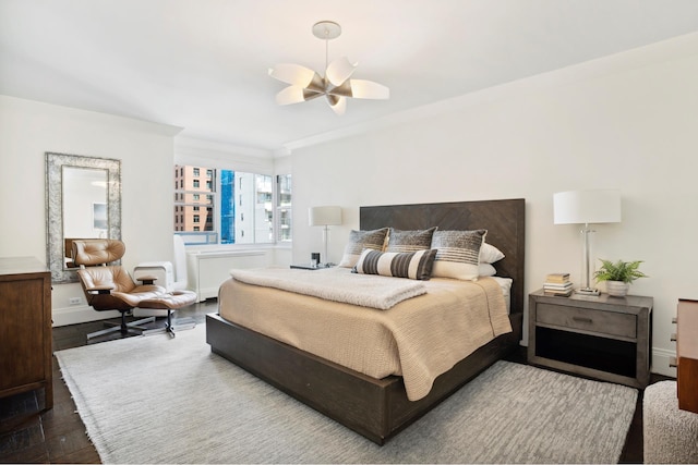 bedroom featuring wood finished floors, baseboards, and crown molding