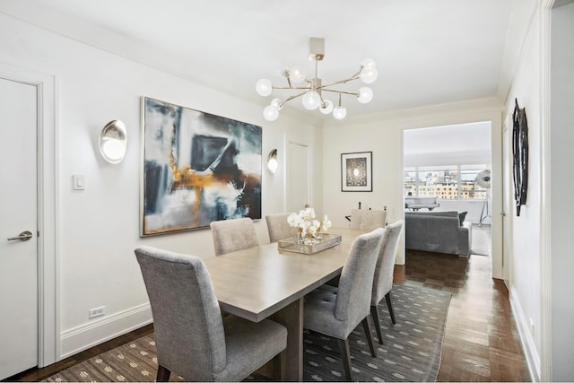 dining space featuring a chandelier, baseboards, and dark wood finished floors