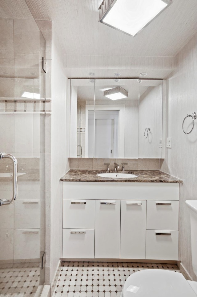 bathroom featuring a stall shower, vanity, and toilet