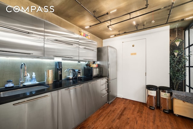14 E 4th St Unit 604, New York City, NY 10012 - kitchen with a sink, dark countertops, dark wood-type flooring, freestanding refrigerator, and decorative backsplash