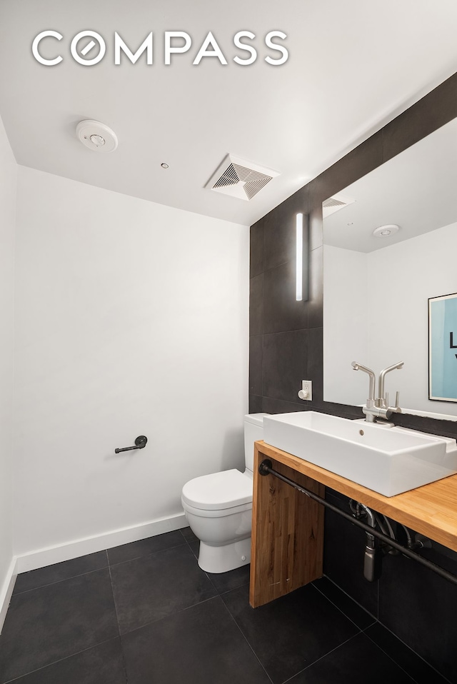 14 E 4th St Unit 604, New York City, NY 10012 - bathroom featuring vanity, toilet, tile patterned floors, and baseboards