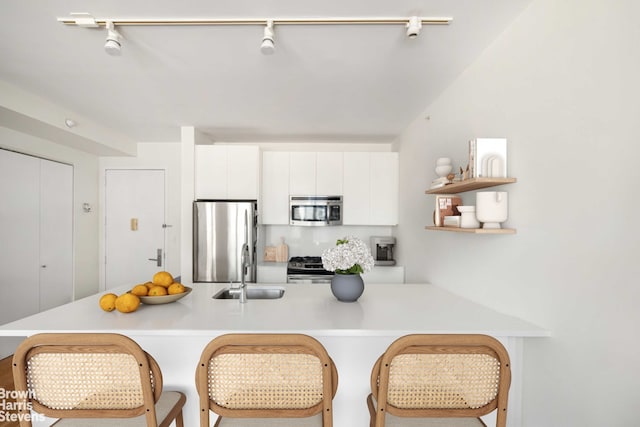 189 Schermerhorn St Unit 21H, New York City, NY 11201 - kitchen with stainless steel appliances, a sink, light countertops, white cabinets, and a breakfast bar