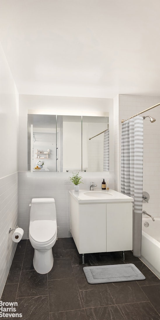 189 Schermerhorn St Unit 21H, New York City, NY 11201 - full bathroom featuring vanity, toilet, shower / bath combo, tile walls, and a wainscoted wall