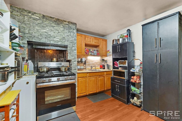13 Suydam Place, New York City, NY 11233 - kitchen featuring appliances with stainless steel finishes, light wood-style floors, tasteful backsplash, and a sink