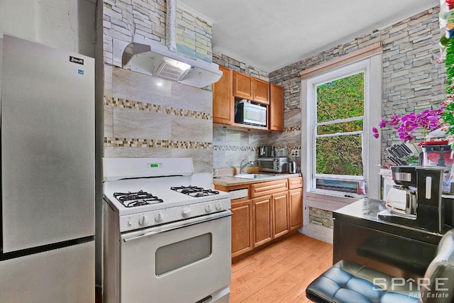 13 Suydam Place, New York City, NY 11233 - kitchen featuring white appliances, light countertops, light wood finished floors, a sink, and brown cabinets