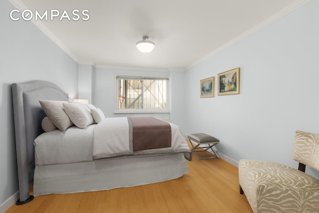 bedroom with crown molding, light wood-type flooring, and baseboards