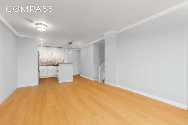 unfurnished living room with crown molding, recessed lighting, baseboards, and light wood-style floors