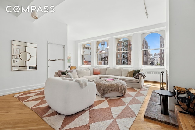 35 E 12th St Unit 8C, New York City, NY 10003 - living area with rail lighting, light wood-style floors, radiator, baseboards, and a view of city