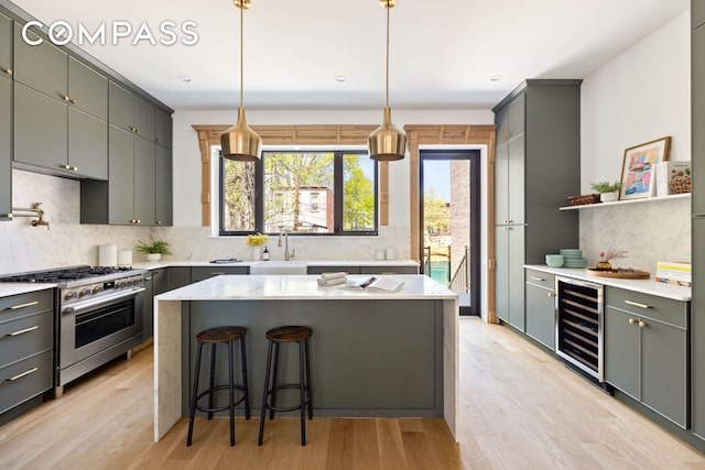 151 Chauncey St, New York City, NY 11233 - kitchen featuring beverage cooler, high end stainless steel range oven, decorative backsplash, and a sink