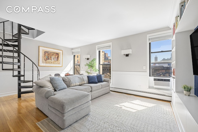 315 W 99th St Pha, Pha, New York City, NY 10025 - living area featuring a baseboard radiator, stairway, wood-type flooring, and plenty of natural light